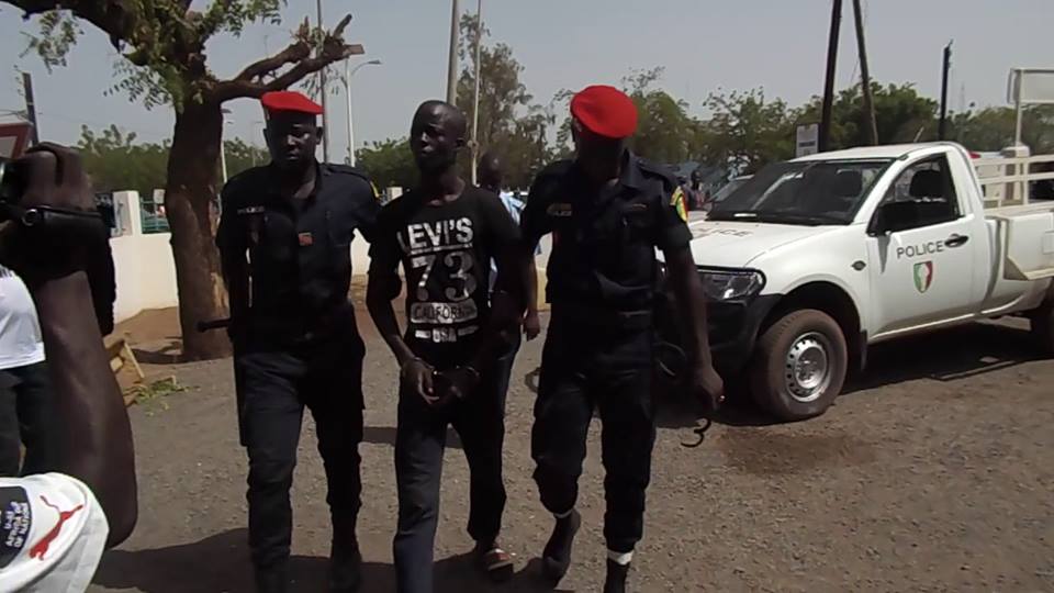 Boy Djinné entouré par deux policiers